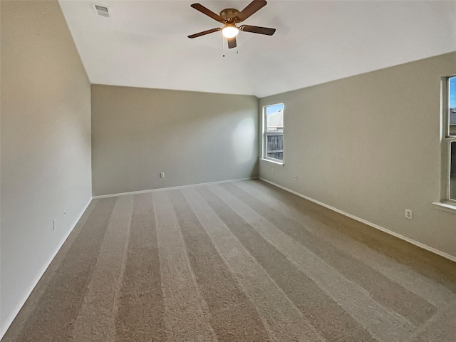 empty room with baseboards, carpet, visible vents, and ceiling fan