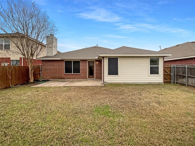 back of house with a patio, a yard, a fenced backyard, and brick siding