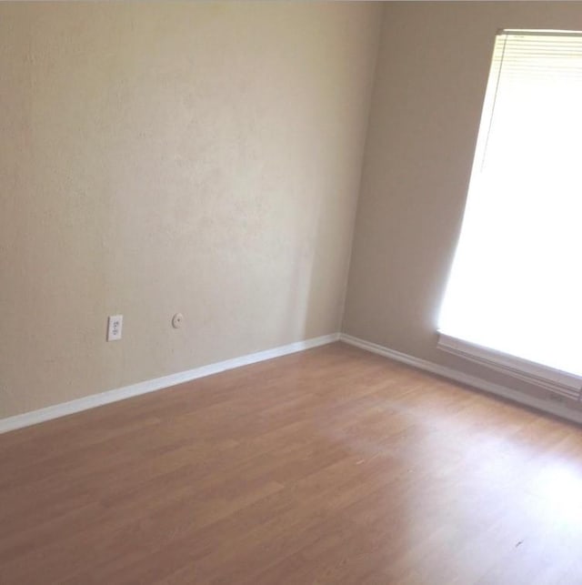 empty room with light wood-style floors and baseboards