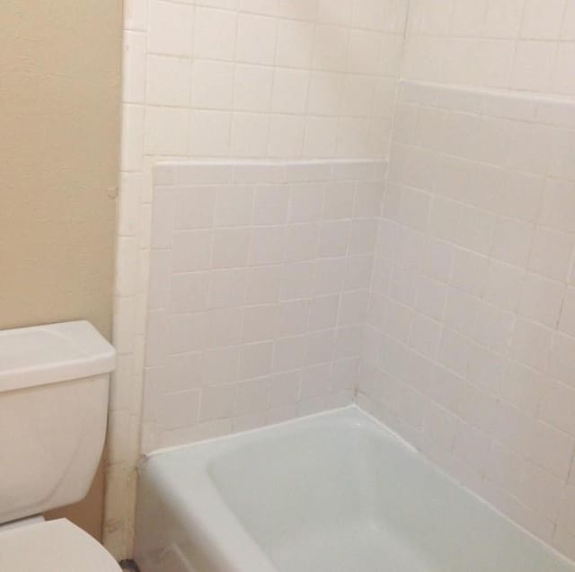 full bathroom featuring a bathing tub, toilet, and walk in shower