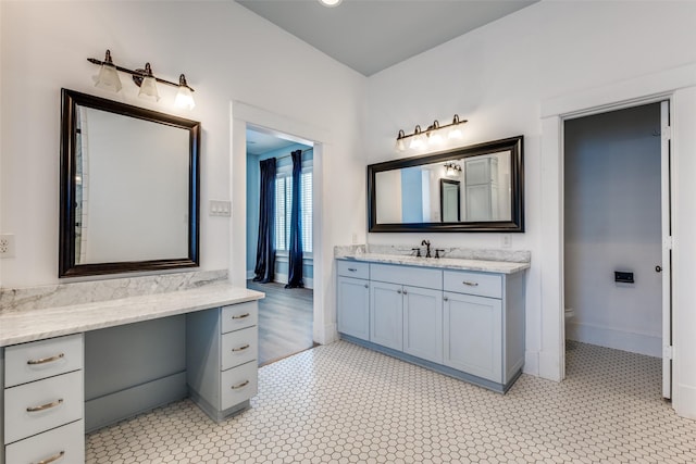 bathroom featuring vanity, tile patterned floors, toilet, and baseboards