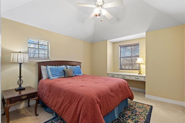 bedroom with vaulted ceiling, multiple windows, baseboards, and light carpet