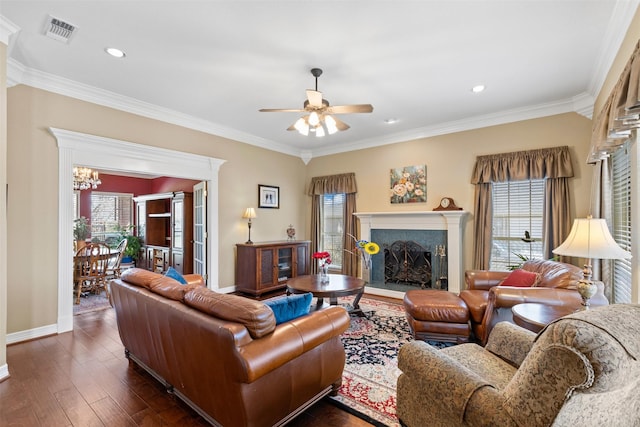 living room with visible vents, ornamental molding, a fireplace, baseboards, and dark wood-style flooring