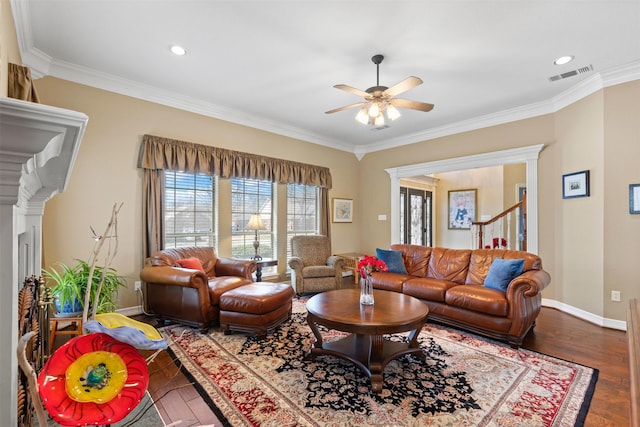 living area featuring a ceiling fan, dark wood-style floors, visible vents, baseboards, and crown molding