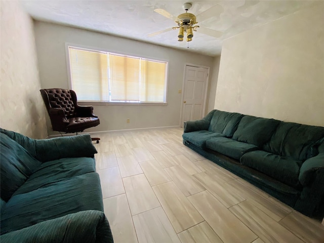 living area with baseboards, ceiling fan, and wood tiled floor