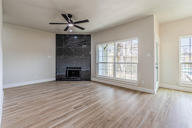 unfurnished living room featuring wood finished floors, a fireplace, and baseboards