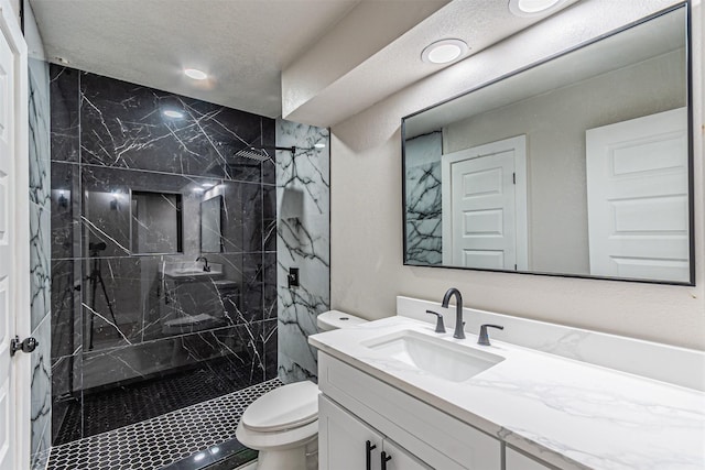 bathroom featuring a marble finish shower, toilet, vanity, and a textured ceiling