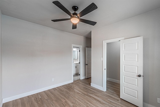 unfurnished bedroom with light wood-type flooring, baseboards, connected bathroom, and a ceiling fan