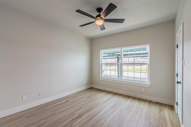 unfurnished room featuring baseboards, light wood-style floors, and a ceiling fan