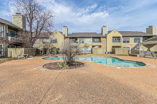 pool with a patio area and fence