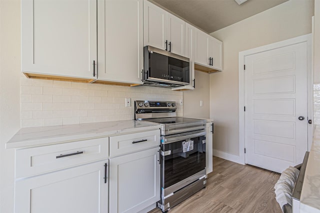 kitchen featuring light stone counters, backsplash, appliances with stainless steel finishes, white cabinets, and light wood finished floors