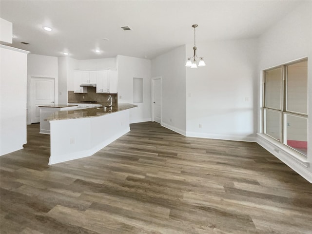 kitchen with visible vents, under cabinet range hood, dark wood finished floors, a chandelier, and white cabinets