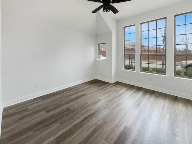 unfurnished room with a wealth of natural light, ceiling fan, baseboards, and dark wood-style flooring