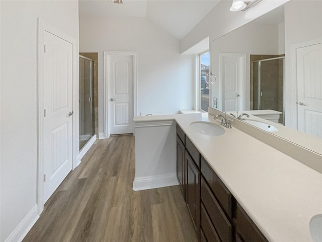 full bath with a shower stall, baseboards, lofted ceiling, wood finished floors, and vanity