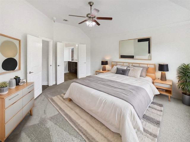 bedroom featuring visible vents, a ceiling fan, ensuite bathroom, light colored carpet, and vaulted ceiling