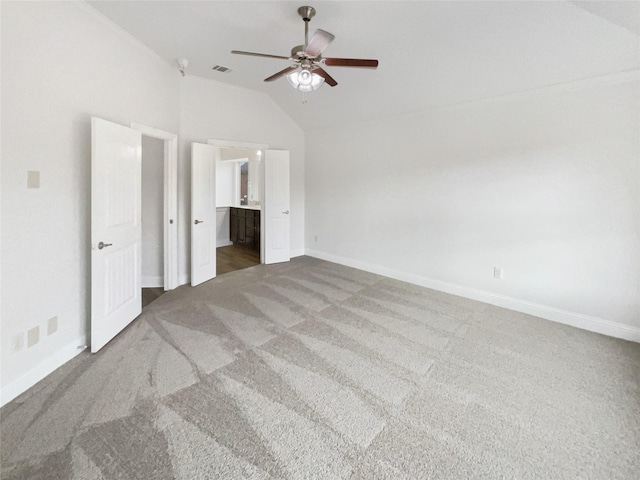 unfurnished bedroom with visible vents, carpet flooring, baseboards, and lofted ceiling