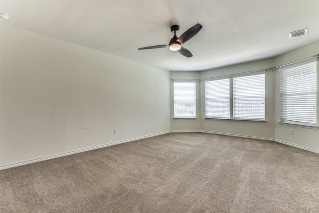 empty room featuring visible vents, baseboards, carpet, and ceiling fan