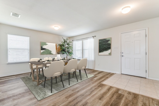 dining area with wood finished floors, visible vents, and baseboards