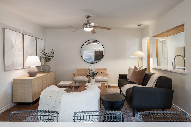 living room with wood finished floors, ceiling fan, baseboards, and visible vents