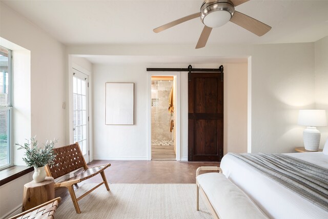 bedroom with visible vents, ensuite bath, finished concrete flooring, a barn door, and baseboards