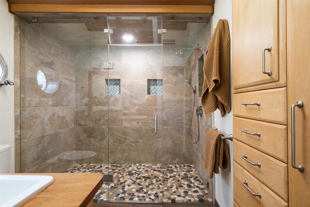 bathroom with visible vents, a shower stall, toilet, vaulted ceiling, and a sink