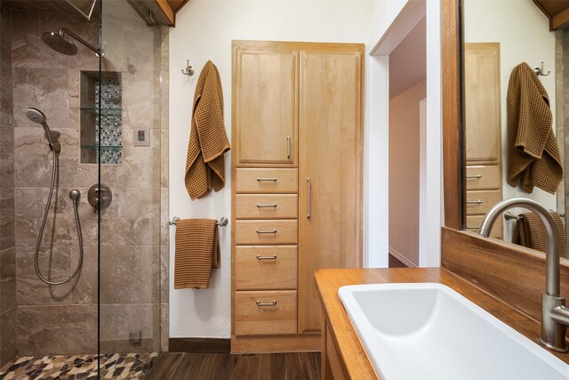 bathroom featuring baseboards, vanity, walk in shower, and wood finished floors