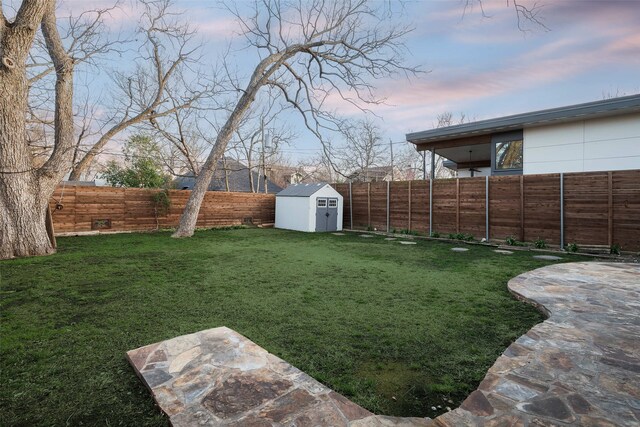 view of yard with an outdoor structure, a storage unit, and a fenced backyard