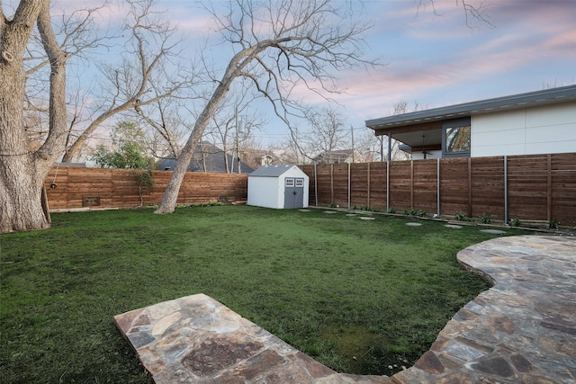 view of yard featuring an outbuilding, a shed, and a fenced backyard