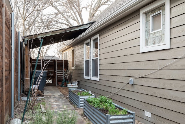 view of home's exterior featuring a garden and fence
