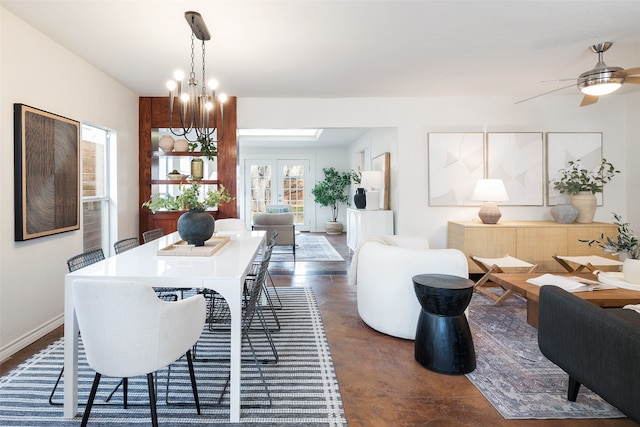 dining space featuring baseboards, ceiling fan with notable chandelier, and concrete flooring