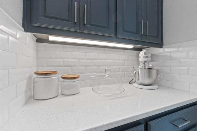 details with light stone counters and blue cabinetry