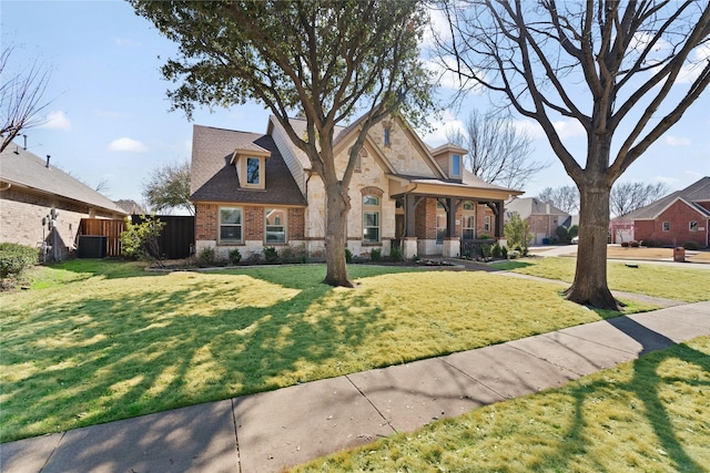 view of front of home featuring a front lawn, stone siding, fence, brick siding, and central AC unit