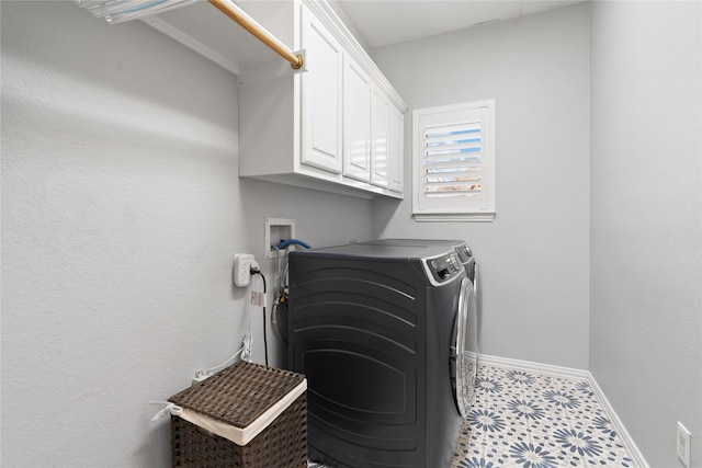 clothes washing area featuring tile patterned floors, baseboards, cabinet space, and washing machine and clothes dryer