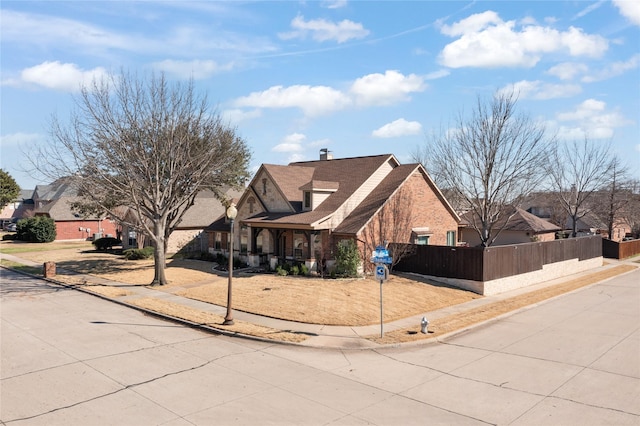 view of front of house featuring a fenced front yard, a residential view, and a chimney