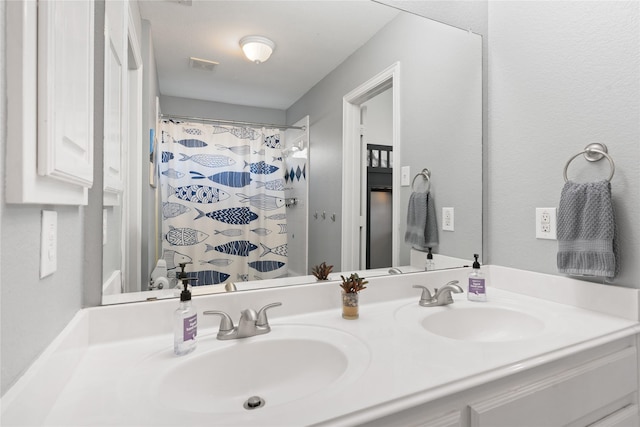 bathroom featuring a sink, visible vents, a shower with shower curtain, and double vanity