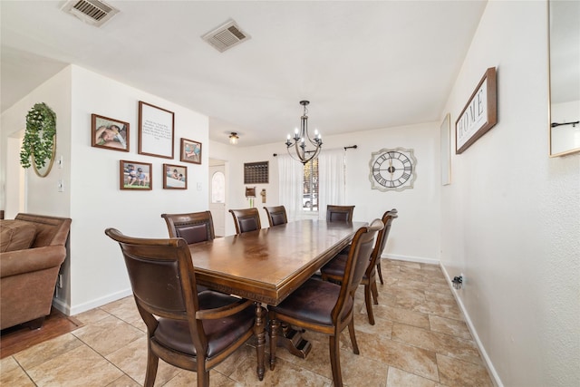 dining space featuring baseboards, visible vents, and a chandelier