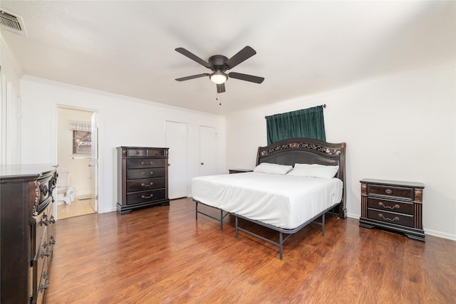 bedroom featuring visible vents, a ceiling fan, wood finished floors, crown molding, and baseboards