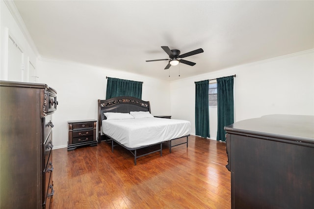 bedroom with a ceiling fan, dark wood-style floors, and crown molding