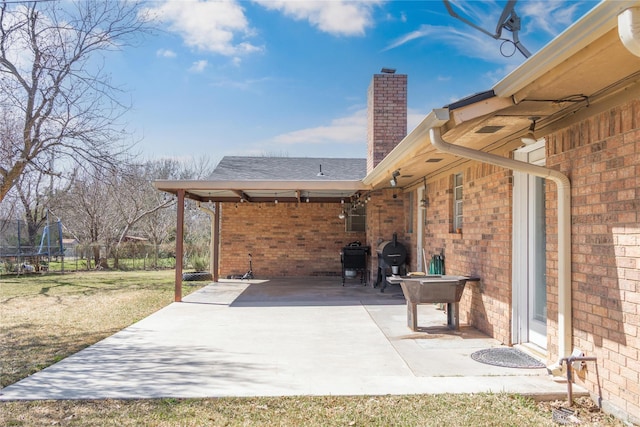 view of patio / terrace with a trampoline and fence