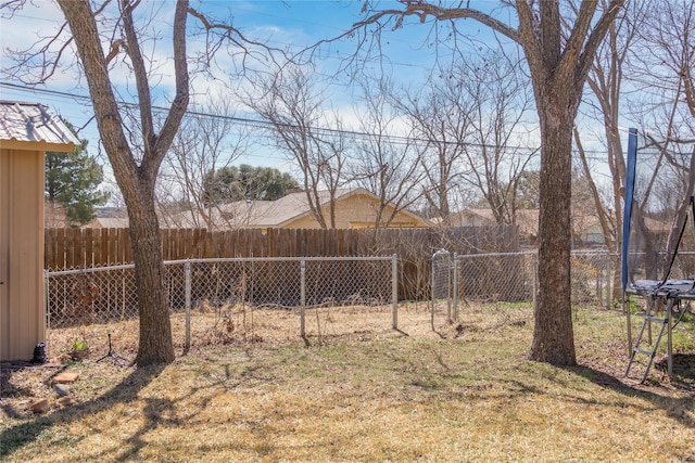 view of yard with a trampoline and a fenced backyard