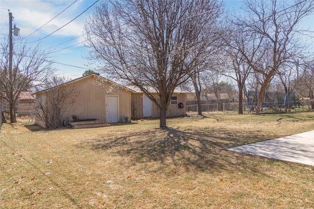 view of yard featuring a trampoline and fence