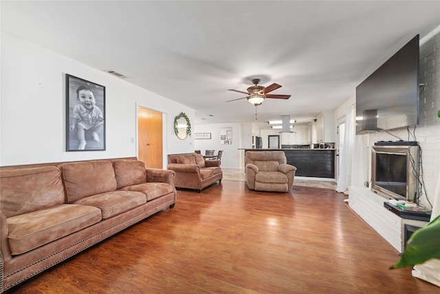 living area featuring dark wood-style floors, visible vents, and a ceiling fan