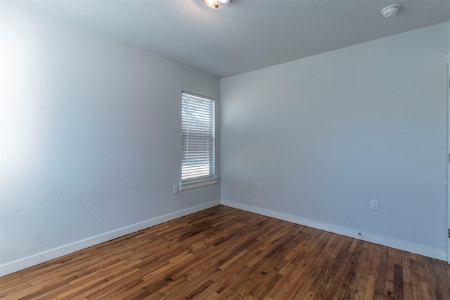 empty room featuring hardwood / wood-style flooring and baseboards