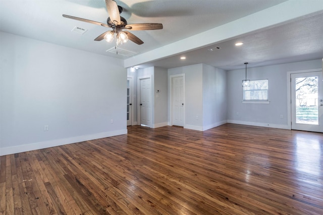 spare room featuring visible vents, baseboards, and dark wood-type flooring