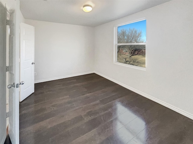 empty room with baseboards and wood finished floors