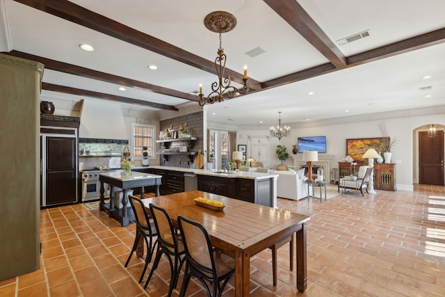 dining room featuring arched walkways, visible vents, recessed lighting, and beam ceiling