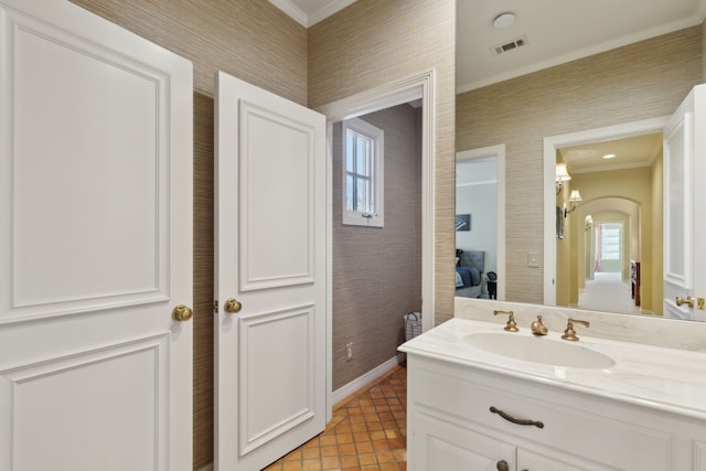 ensuite bathroom with vanity, visible vents, plenty of natural light, ornamental molding, and connected bathroom