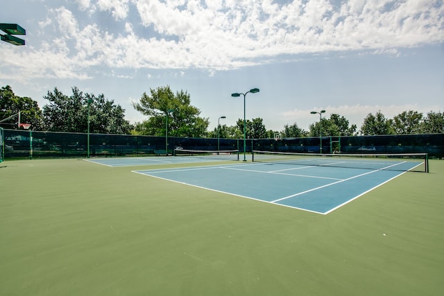 view of tennis court featuring fence