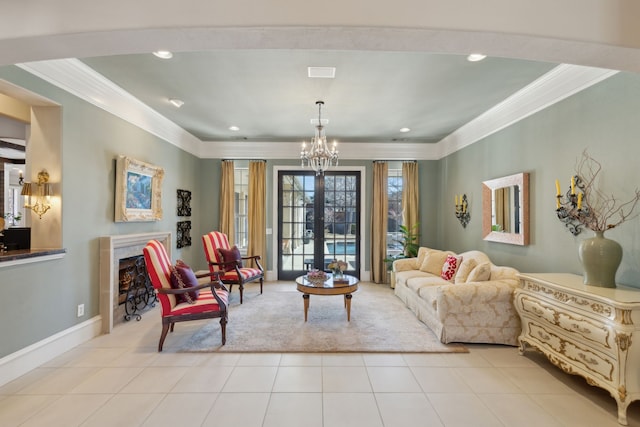 sitting room featuring tile patterned flooring, baseboards, a tiled fireplace, a chandelier, and ornamental molding