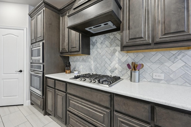 kitchen featuring custom exhaust hood, appliances with stainless steel finishes, and dark brown cabinetry